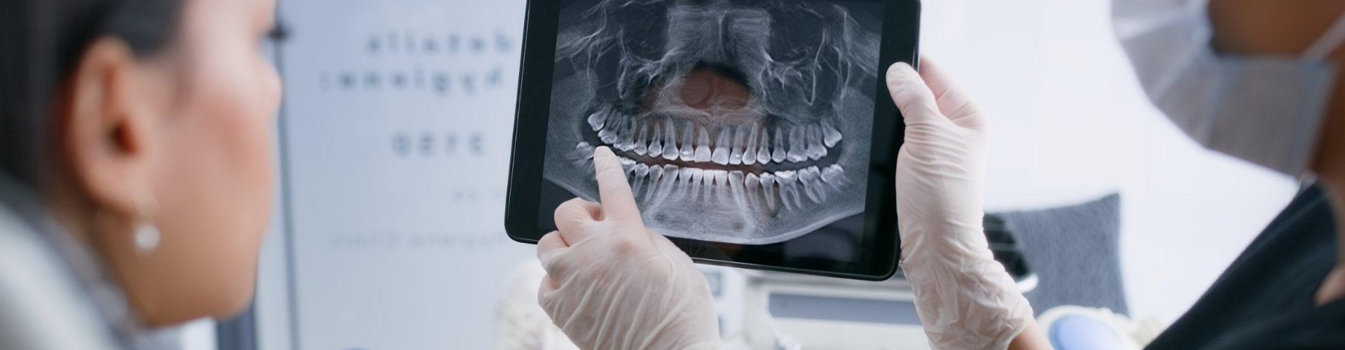 Gloved hands holding a dental X-ray.